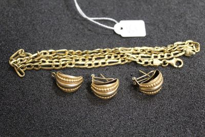 a close up of a gold chain bracelet with three charms