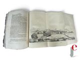 an open book with a picture of a town on it