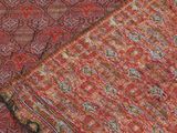 a close up of a red and green paisley pattern on a red ground