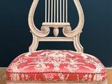 une chaise rouge et blanche posée sur un parquet en bois dur