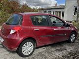 une petite voiture rouge garée devant une maison