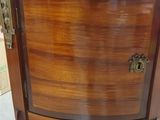 a small wooden cabinet with a marble top on display