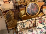 beaucoup de meubles dans une pièce où il y a beaucoup de tableaux accrochés aux murs