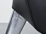 a close up of a metal object on a black chair