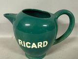 une théière verte sur laquelle est inscrit le mot « Ricard »