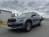 une voiture grise garée dans un parking à côté d'un bâtiment
