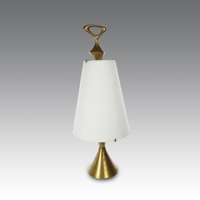 une lampe de table en laiton surmontée d'un abat-jour blanc