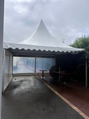une tente blanche avec une table à l'intérieur, au bord de la route