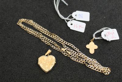un gros plan sur un collier orné d'une croix et d'un cœur