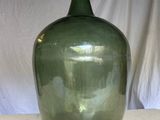 a large green glass bottle sitting on a table