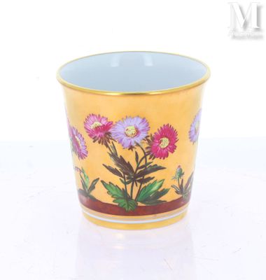 une tasse sur laquelle sont peintes des fleurs sur un fond blanc