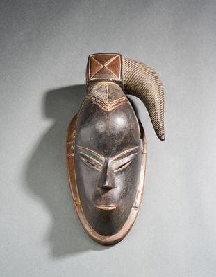 un masque en bois accroché au mur