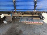 the back end of a blue truck with a red and white stripe on it