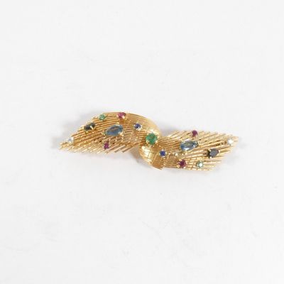 une image représentant une broche plaquée or ornée de pierres multicolores