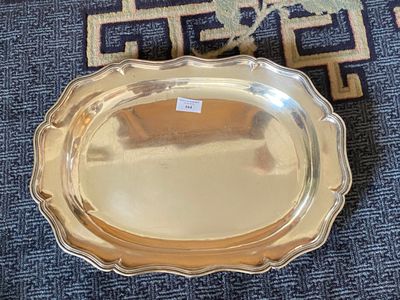 a silver tray on the floor next to a blue rug
