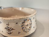 a white bowl with blue flowers on it on a table