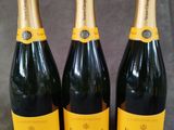 trois bouteilles de champagne posées les unes à côté des autres sur une table