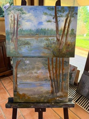 peinture sur chevalet devant un tableau représentant un lac et des arbres