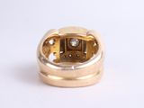 a gold ring with a diamond in it on a white surface