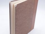 a book with a brown cover on a white surface