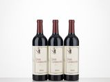 three bottles of red wine sitting on top of a table