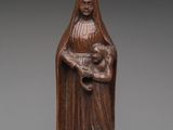 une statue en bois représentant une femme tenant un enfant