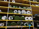 de nombreux rouleaux de moquette verte sur les rayons du magasin