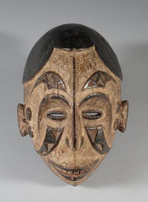 une image représentant un masque en bois au visage noir sur fond blanc