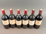 six bottles of wine are lined up in a row on a table