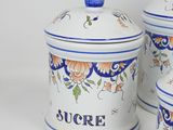 three canisters with blue and white designs on them
