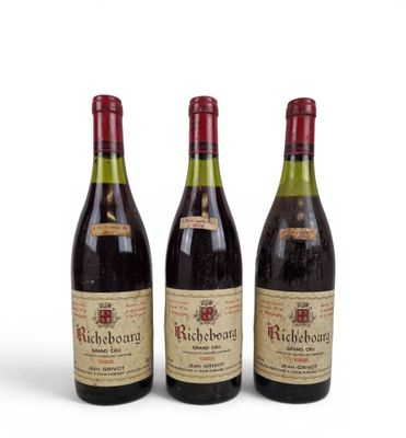 three bottles of wine are lined up on a white surface