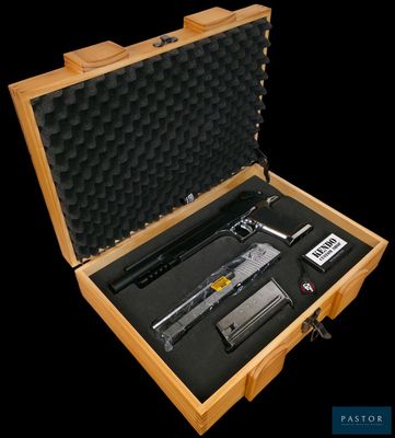 un coffret en bois contenant un pistolet, sur fond noir