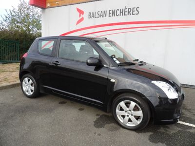 a picture of a small black car parked in front of a building