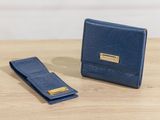 the blue wallet is next to a small wallet on a wooden table