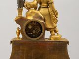 a gold statue of a woman sitting on top of a clock