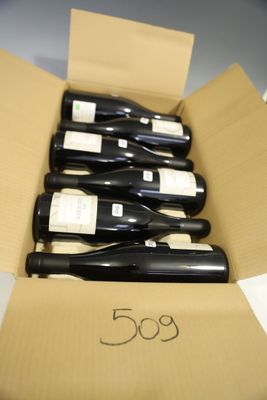 several bottles of wine are in a cardboard box on a table