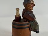 a figurine of a man sitting in a barrel with a bottle of wine
