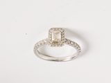 a close up of a diamond ring on a white surface