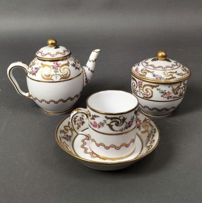 un service à thé en porcelaine composé de trois pièces, posé sur un fond noir