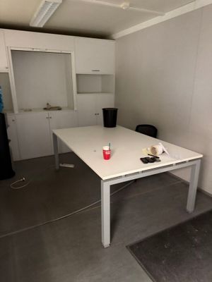 a white table with a red cup on it in a room