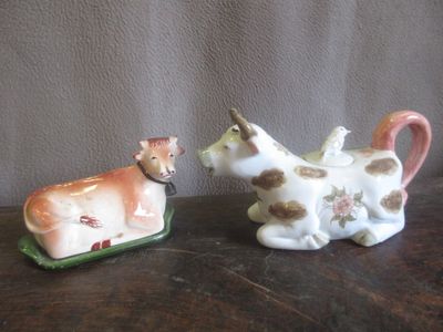 Lot de 2 vaches : Théière en porcelaine - L. 28 cm et Beurrier en faïe - Photo 1