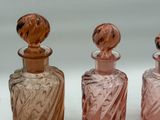 three different colored glass bottles sitting next to each other