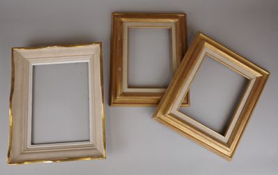 three gold picture frames sitting on top of a white table