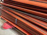 une pile de tiges métalliques orange posées sur le sol