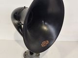 an old fashioned black speaker on a metal stand on a white surface