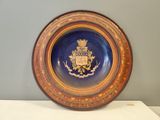 une assiette bleue et dorée sur laquelle figure un blason