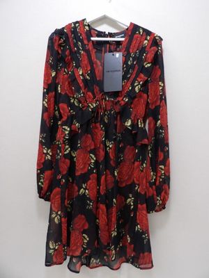 une robe à fleurs noire et rouge suspendue à un cintre