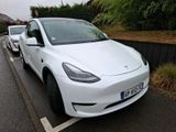 a white tesla car parked on the side of the road