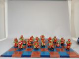 a lot of figurines that are sitting on a chess board