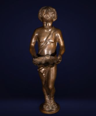 une statue en bronze représentant un garçon tenant un poisson